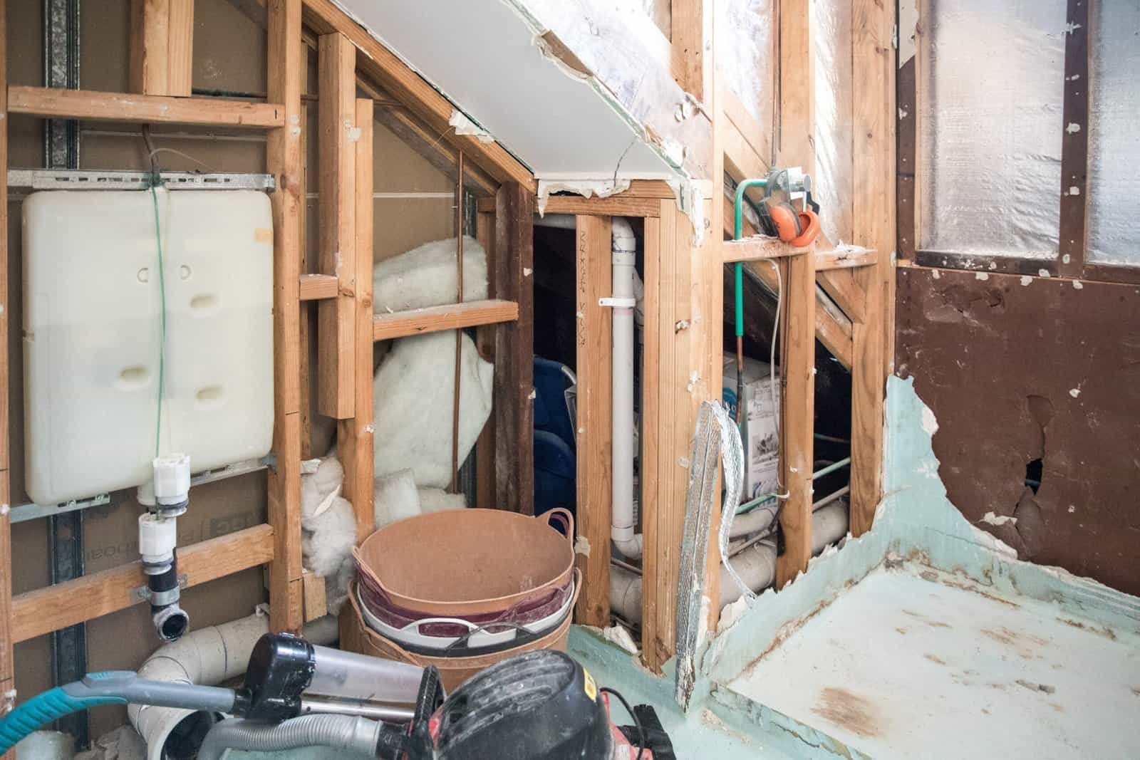 Construction site with insulation and plumbing installation in progress.